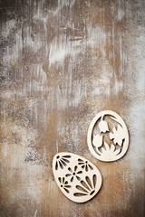 Symbols of Easter wooden decorative eggs and  rabbit on an old brown concrete or stone background. Selective focus. Top view. Place for text.