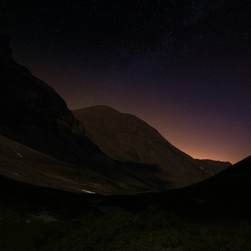 A view of the night starry sky in a mountain valley.
