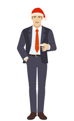 Businessman in Santa hat  with hand in pocket gives a business card