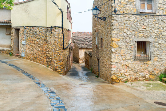 Fototapeta Old street in a european town with road and stone buildings