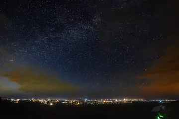  De Melkweg van de sterrenhemel boven de stad. © olgapkurguzova