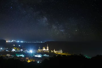 Foto op Plexiglas De Melkweg van de sterrenhemel boven de stad. © olgapkurguzova