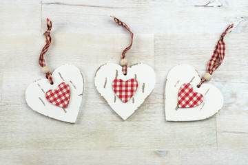 Three hearts of wood on wooden background