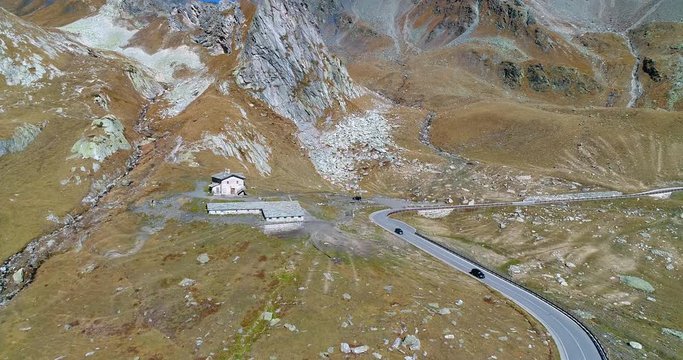 Cars on a mountain road, Cinema 4k view over vehicles on a alp road, in harsh nature between mountains, on a sunny autumn october day, on grand san bernardo pass, in switzerland