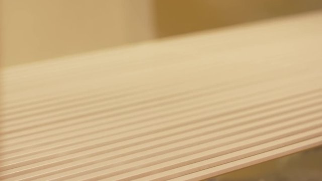 worker hand sprays polish to mdf planks