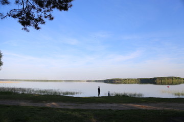 mother with a child on a lake and blue sky background. Zaslavskoe Reservoir, Minsk Region