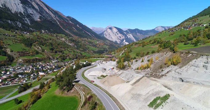 Alpine landscape, Cinema 4k rising view of a town, snowy mountains and colorful fall trees, on a sunny autumn october day, near grand san bernard pass, Switzerland