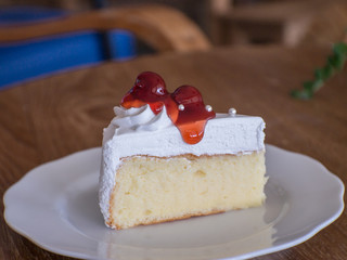 Cake topped with strawberry sauce. Put on a wooden table in a coffee shop.
