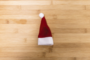 Obraz na płótnie Canvas Small old dirty Christmas decoration hat isolated on a wooden background