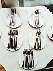Silberbesteck Messer und Gabeln auf Servietten und Tellern im Restaurant