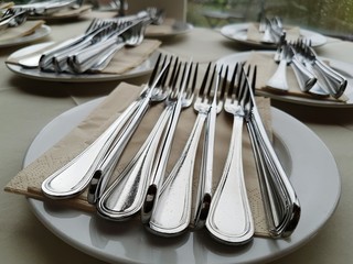 Silberbesteck Messer und Gabeln auf Servietten und Tellern im Restaurant