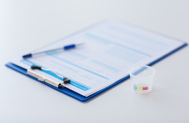 clipboard with report and drugs in medical cup