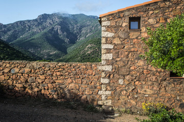 stone wall enlightened sun with small window in the mountains on the island of Corsica