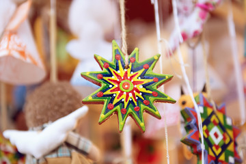 Wooden Christmas stars, holiday balls and other author's souvenirs at the Christmas outdoor market, seasonal festive background