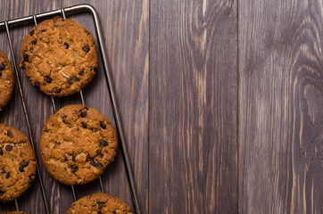 Homemade oatmeal cookies on cooling rack. Wooden background. Flat top view.
