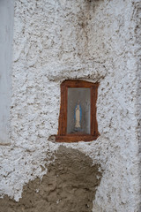 figure of a virgin in an altar on the wall of a house