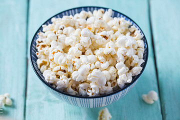 salty popcorn on turquoise wooden surface