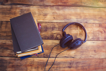 Headphones and a pile of Books on the Wooden Background. Audiobook Concept