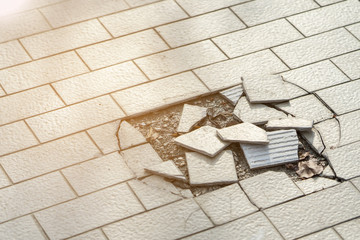 Cracked and broken tiles floor .