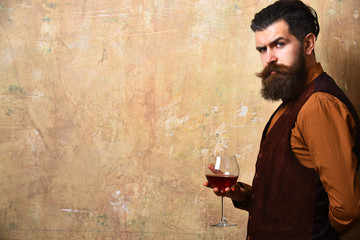 Sommelier with confident face drinks wine glass