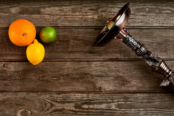 Dismantled part of hookah on a wooden background with lime fruit