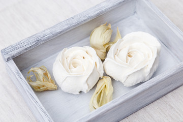 White marshmallow flowers tulips in a old wooden box. Beautifully decorated dessert. Low-calorie sweetness. Top view.