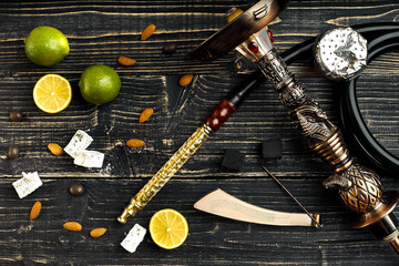 Dismantled parts of hookah on a wooden background with lime frui