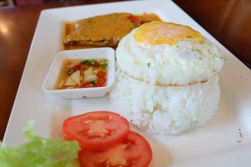 Fried egg eating with spicy curry fish