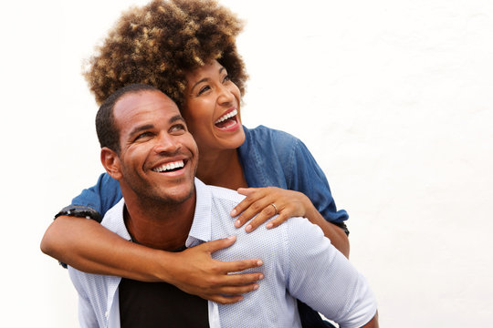 smiling couple standing in embrace on white background