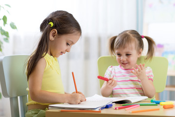 happy children drawing in nursery room