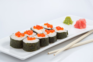 sushi or rolls on a long plate, wooden sticks, red ginger and wasabi