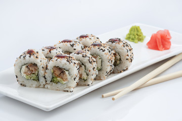 sushi or rolls on a long plate, wooden sticks, red ginger and wasabi