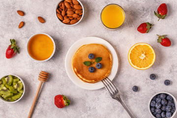 Pancakes with fruit, honey, nuts.
