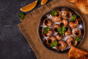 Fried snails with lemon, baguette and parsley.