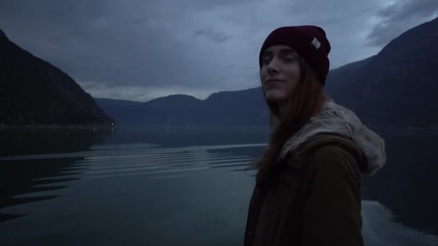 Young woman walks alone surrounded by Norwegian fjords