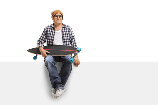 Old Hipster With A Longboard Sitting On A Panel