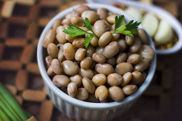 Feijão carioca prato tradicional da cozinha brasileira acompanhado de temperos em uma mesa rustica.