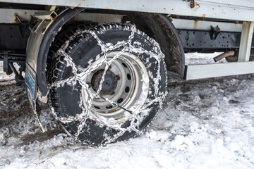 Snow chains on truck tire in the snow