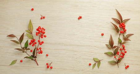 Christmas Red berries of sacred bamboo (Nandina Domestica) flowers on wooden background.