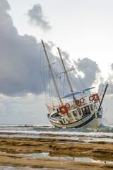 Fototapeta premium Wrecked boat abandoned stand on beach in RHodes Greece