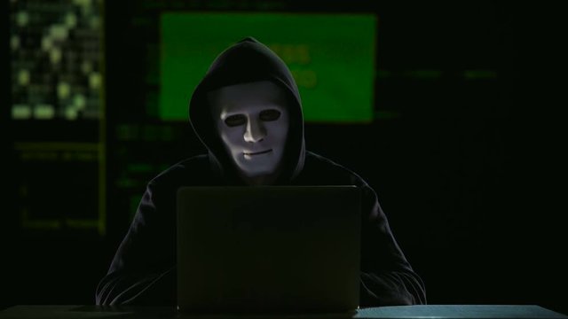 Dark person in mask satisfied with his work, sign access granted on big screen
