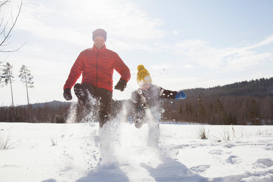 Man and son marching in snow covered landscape