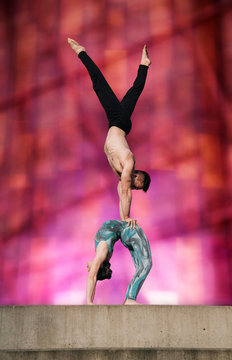 Teenage girl and young man, girl bent backwards in arch, man doing handstand on girls stomach