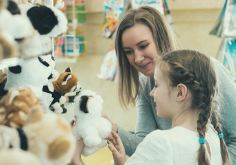 Woman and her daughter choosing toy in kids store. © M-Production