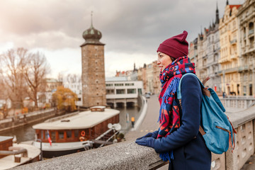 Obraz premium Woman tourist in a coat with a backpack travels in the Prague city