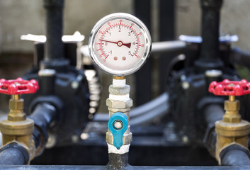 Closeup of manometer (pressure gauge). Chrome pipes and valves with measuring gas pressure on oil...