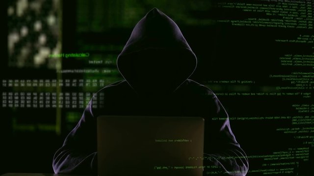 Hacker opening laptop to check virus breaking system codes, stealing data