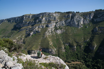 Fototapeta na wymiar Escursionista seduto sull'abisso, riserva naturale orientata Cavagrande del Cassibile 