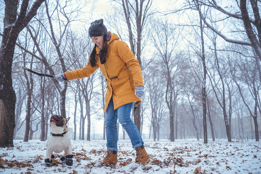 woman playing with french bulldog