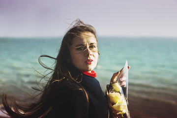Beautiful girl with white roses on a background of the sea